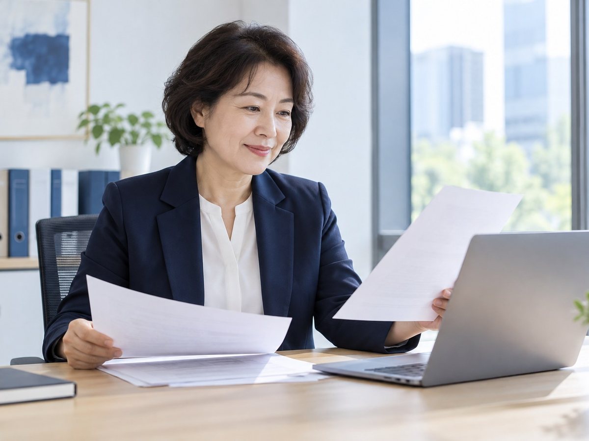 호텔 PG단말기 · 여성이 서류를 들고 노트북 앞에서 확인하는 장면(연출 사진)